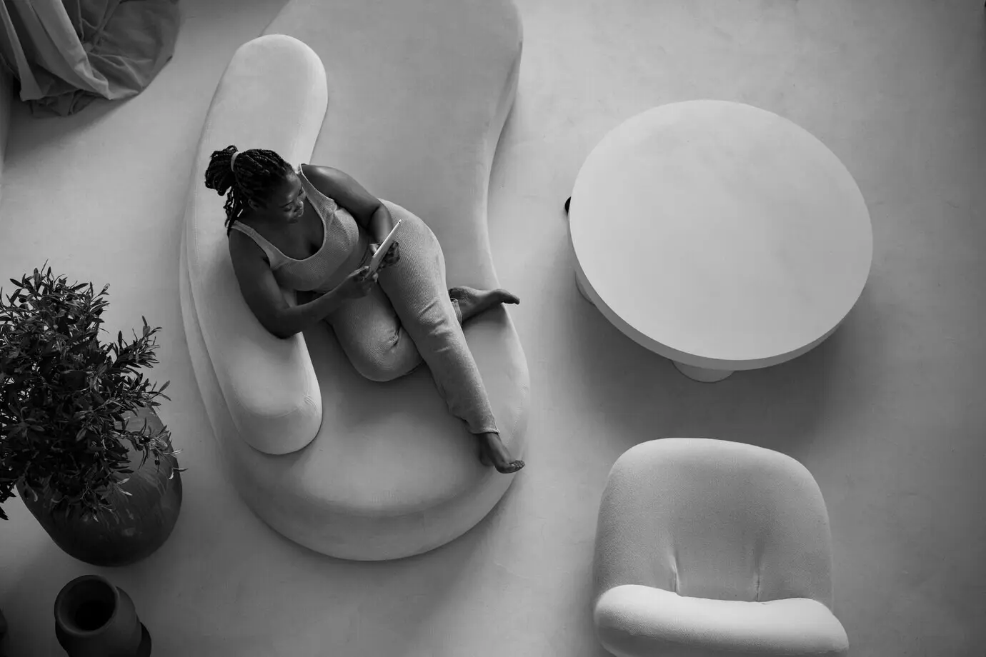 Draufsicht auf eine Frau mit Tablet auf einem Sofa.